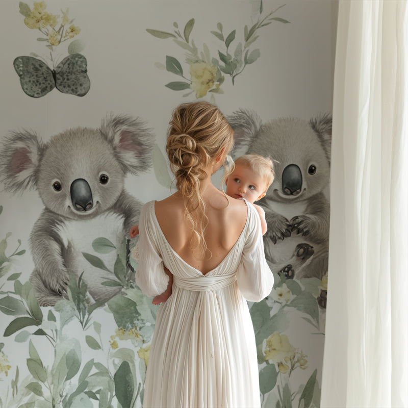 Koala and butterfly mural adding charm to a baby's nursery with rocking chair and mobile