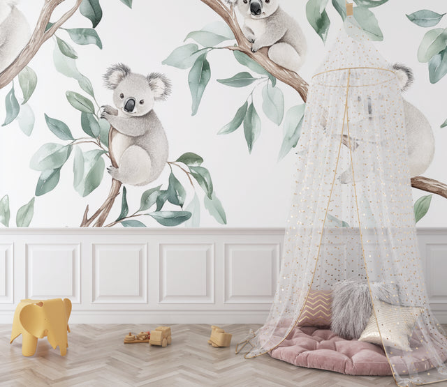 Koala wallpaper mural in a bright nursery with white furniture and natural accents