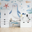 Marine animals wallpaper in bright nursery with white furniture showing playful seal and starfish design