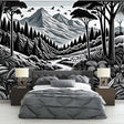 Black and white mountain forest wallpaper mural creating a dramatic focal point in a modern living room with minimal furniture