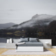 Mountain lake wallpaper creating depth in modern living room with grey sofa and natural light