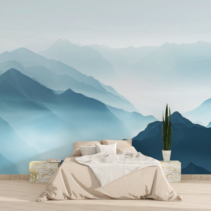 Mountain landscape wallpaper creating depth in modern living room with grey sofa and natural light