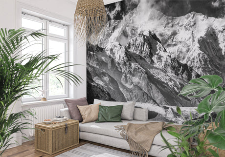 Mountain peak wallpaper creating depth in modern living room with grey sofa and natural light