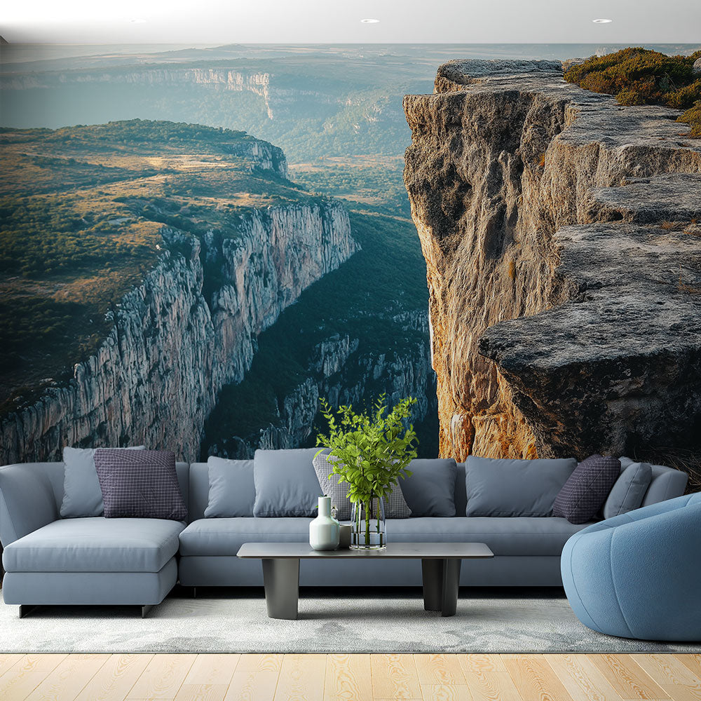 Mountain wall mural creating depth in modern living room, showing dramatic cliff panorama against misty horizon