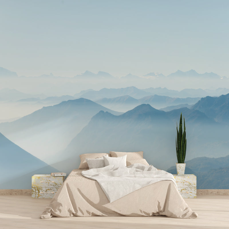 Mountain landscape wallpaper in dining room with natural wood table and chairs