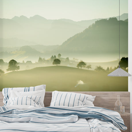 Mountain landscape wallpaper creating depth in a modern living room with grey sofa and natural light