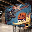Rock and roll graffiti wallpaper creating urban atmosphere in a modern teen bedroom with blue and orange tones