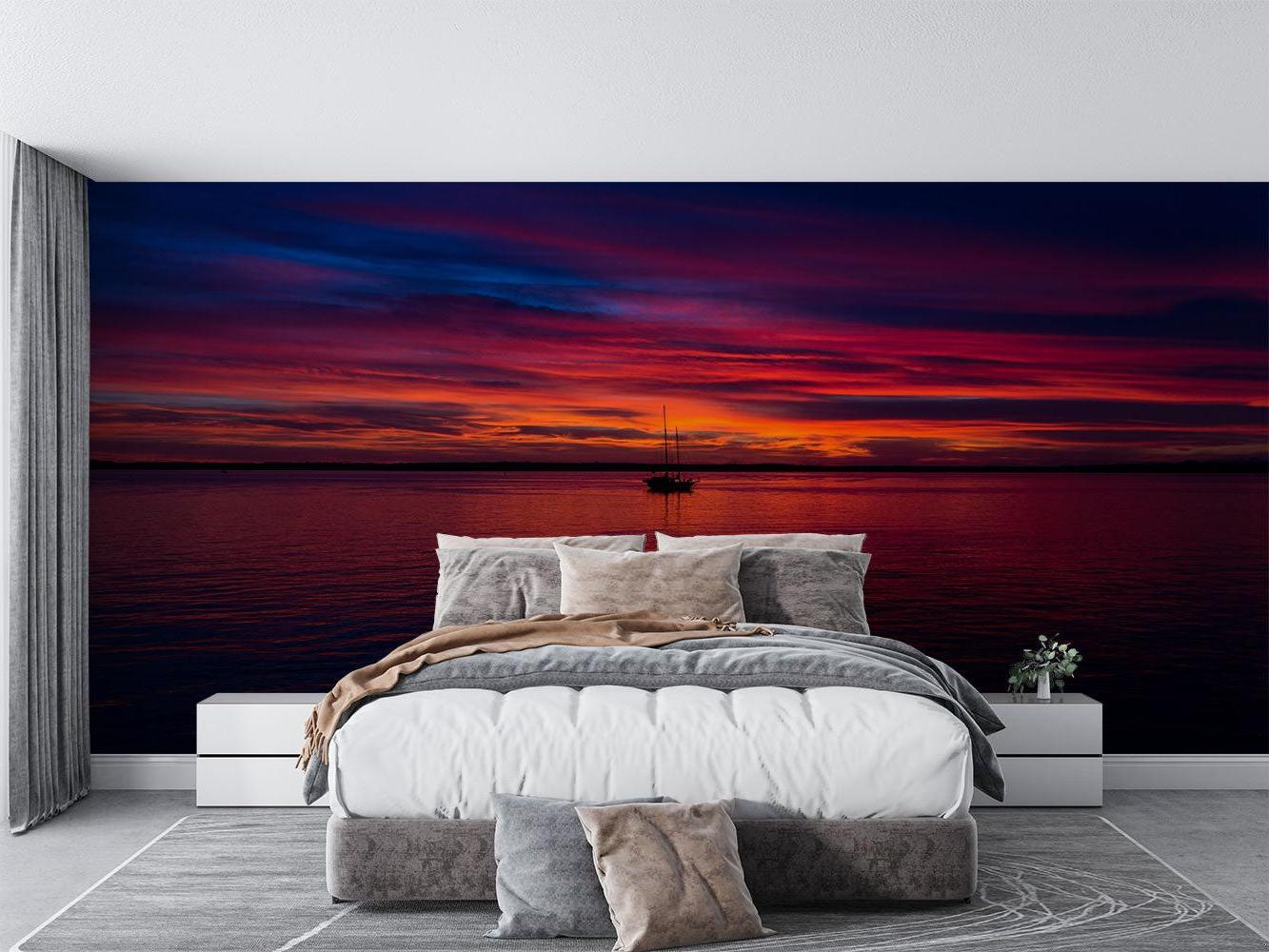 Dramatic red sunset seascape wallpaper as a stunning backdrop in a master bedroom suite