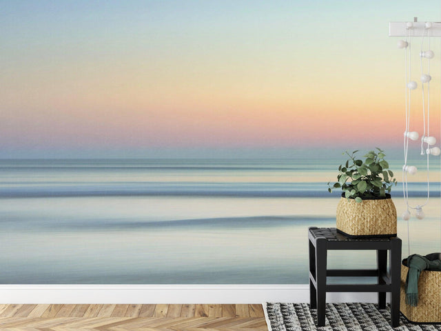 Ocean sunset wallpaper creating a calm atmosphere in a modern living room with minimal furniture