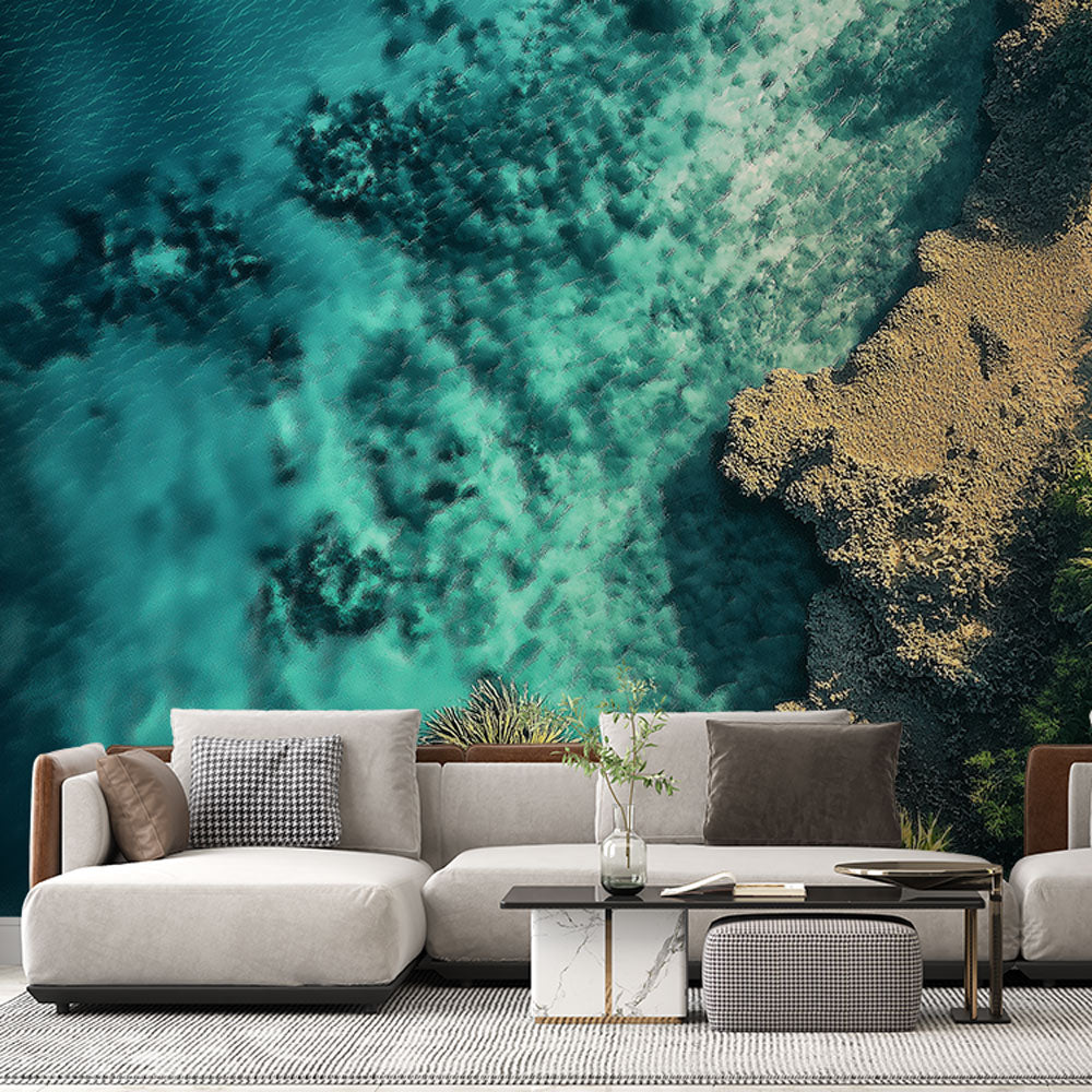Bright ocean view wallpaper in modern living room, showing turquoise waters meeting sandy beach from above