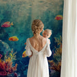 Ocean mural wallpaper creating depth in modern living room with turquoise and coral tones
