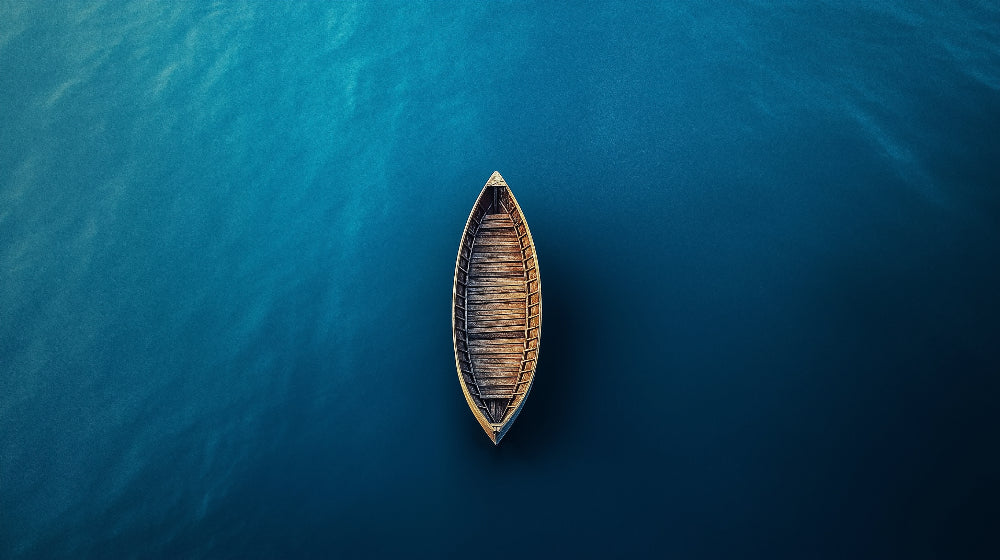 Ocean wallpaper design file showing aerial view of wooden boat floating on deep blue waters