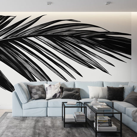 Black and white palm leaf mural wallpaper creating a stunning focal point in a modern living room with high ceilings