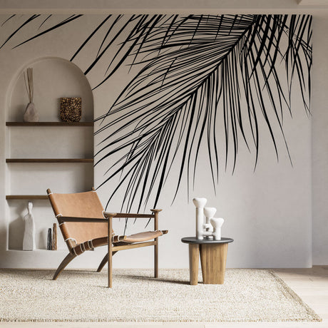 Black and white palm leaf mural wallpaper creating dramatic focal point in modern minimalist living room