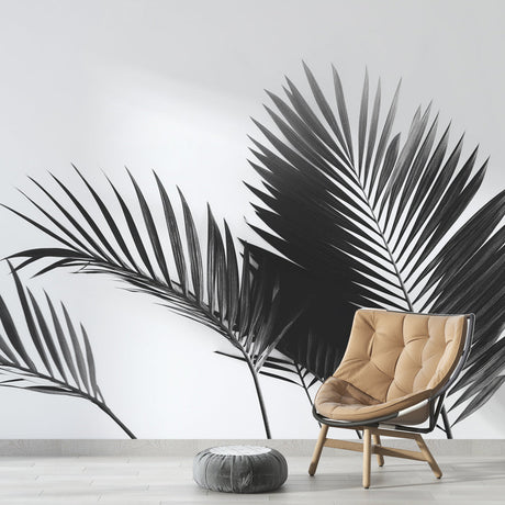 Black and white palm leaf wallpaper creating drama in a modern living room with clean furniture and natural light