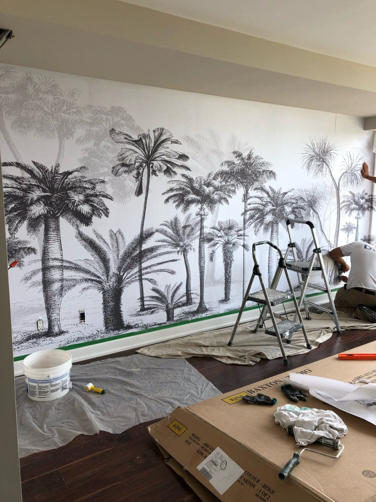 Monochrome tropical forest mural in a cozy bedroom setting with natural light and simple decor