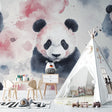 Pink watercolor panda wallpaper in a cozy nursery with white furniture and soft textiles