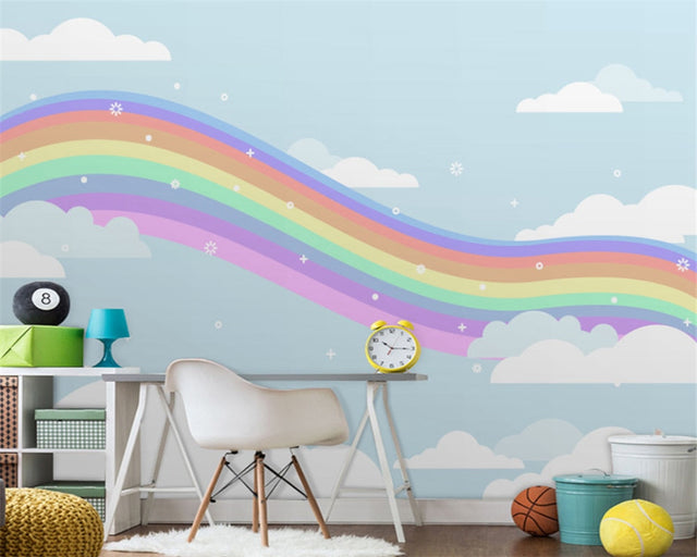 Rainbow wallpaper mural in bright nursery with white furniture showing soft pastel colors and dreamy clouds