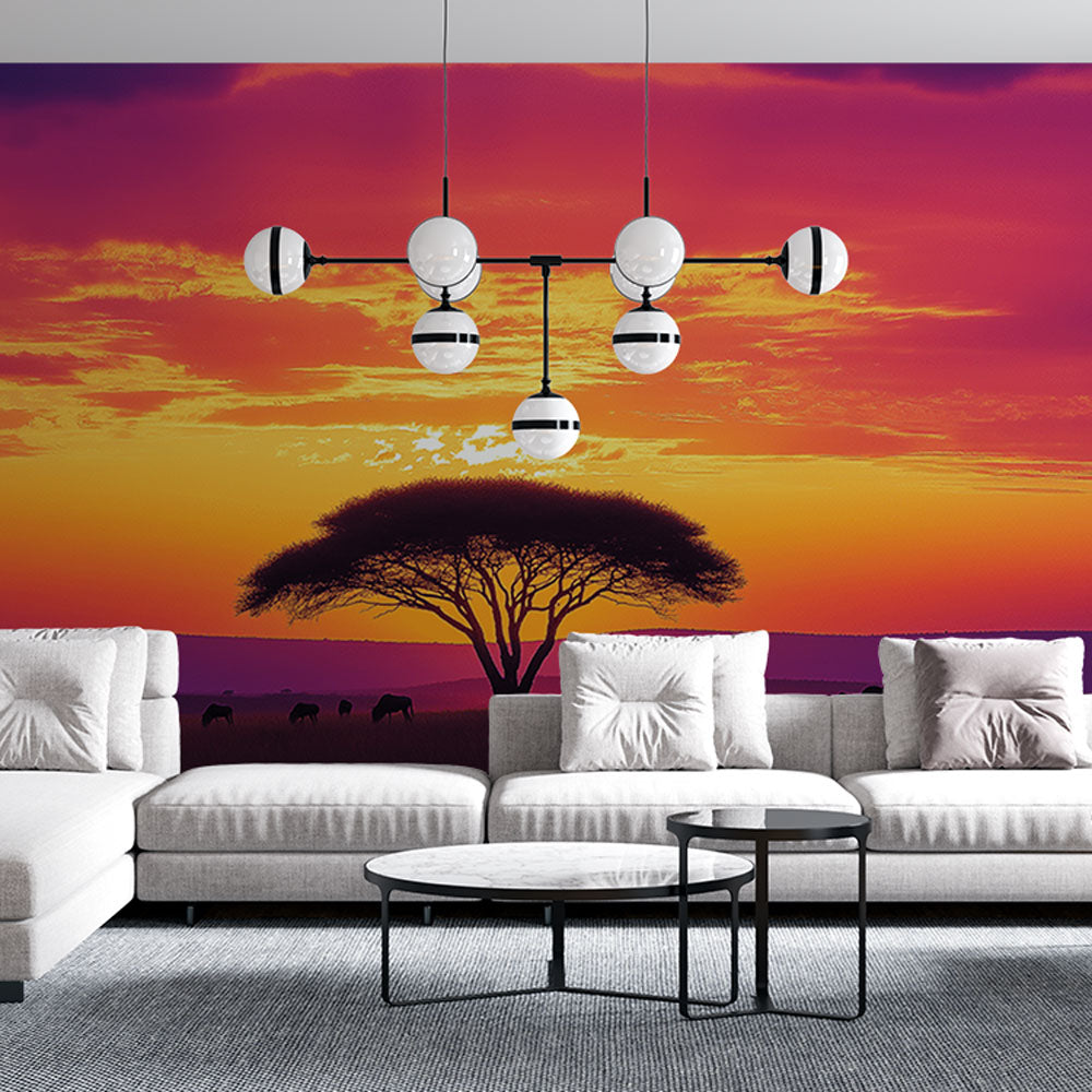 African savanna wallpaper mural displayed in a modern living room, showing sunset colors and wildlife silhouettes