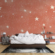 Terracotta star wallpaper in a cozy bedroom creating a warm, dreamy atmosphere