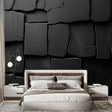 Black stone textured wallpaper creating dramatic accent wall in modern living room with sleek furniture