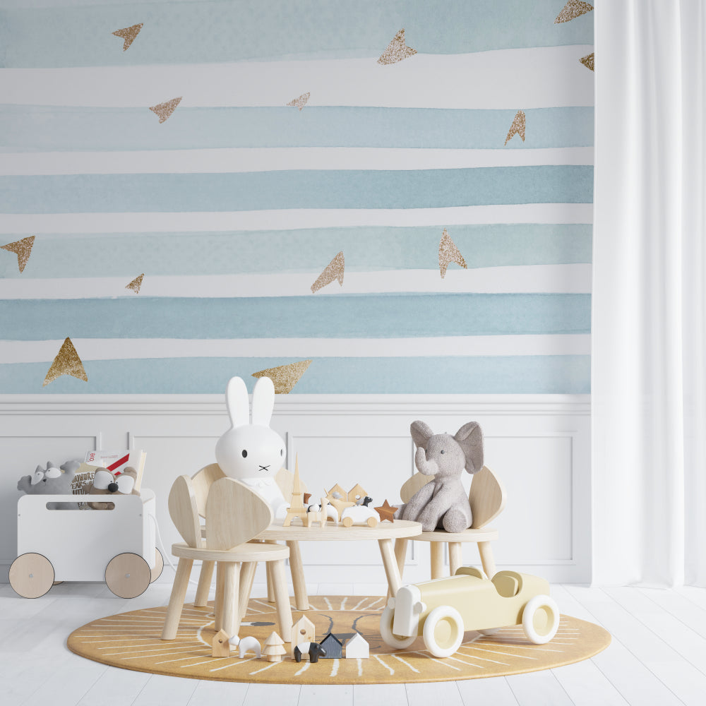 Striped nursery wallpaper featuring blue and gold design in a cozy reading nook setting