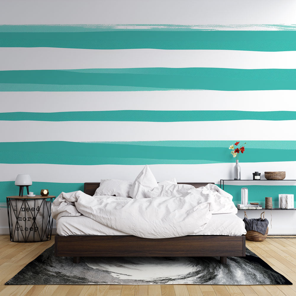Modern striped wallpaper in turquoise and white creating a fresh coastal feel in a bright living room with minimalist furniture