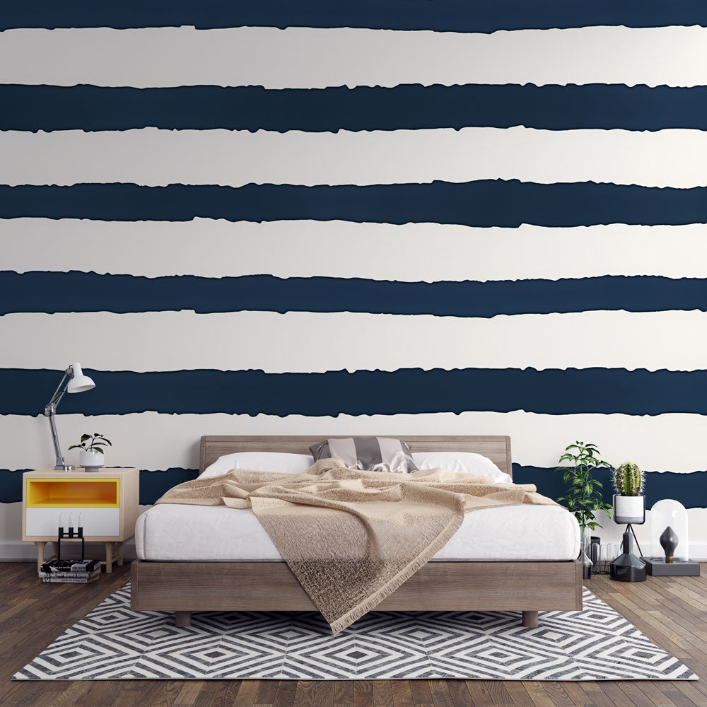 Navy striped wallpaper creating a bold coastal look in a modern living room with white furniture
