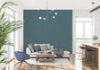 Teal textured wallpaper creating depth in a modern living room with natural light highlighting the organic pattern