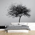 Black and white tree mural wallpaper creating a striking focal point in a modern minimalist living room