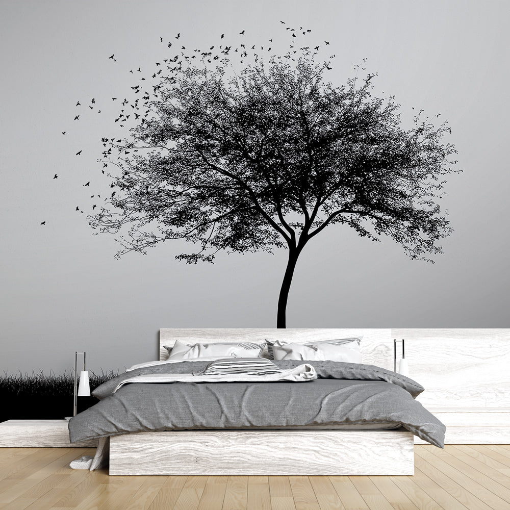 Black and white tree mural wallpaper creating a striking focal point in a modern minimalist living room