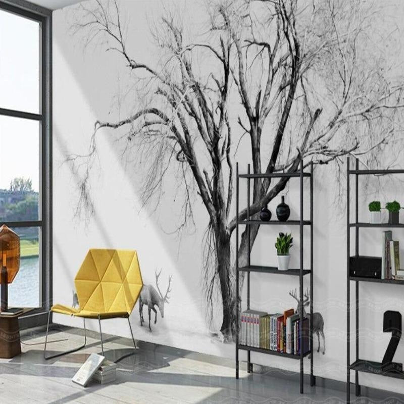 Black and white tree wallpaper creating depth in a modern living room with grey sofa and natural light
