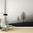 Black and white tree wallpaper mural creating a peaceful atmosphere in a modern minimalist living room setting
