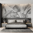 Black and white tropical leaf wallpaper creating drama in modern living room with grey sofa