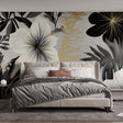 Black and gold tropical wallpaper mural creating a stunning backdrop in a modern dining room with ambient lighting