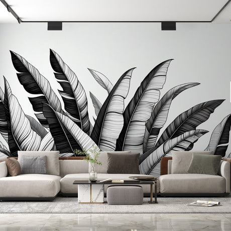 Black and white tropical leaf wallpaper creating a dramatic focal point in a modern living room with minimal furniture
