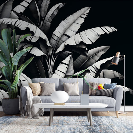 Black and white tropical leaf wallpaper creating drama in a modern living room with clean lines and natural light