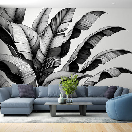 Black and white tropical leaf wallpaper creating dramatic impact in modern living room with minimal furniture