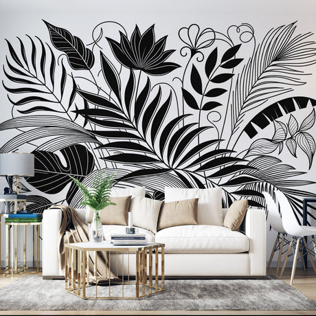 Black and white tropical leaf wallpaper creating a dramatic statement wall in a modern living room with minimalist furniture