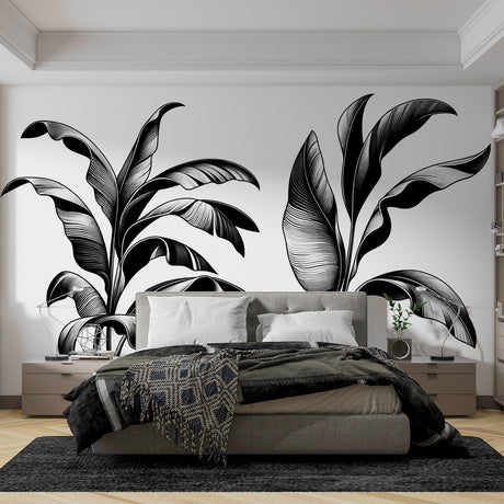 Black and white tropical leaf wallpaper creating a bold statement in a modern minimalist living room with white furniture