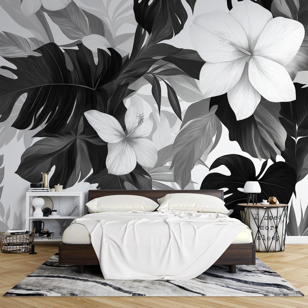 Black and white tropical wallpaper with Monstera leaves creating drama in a modern living room setting
