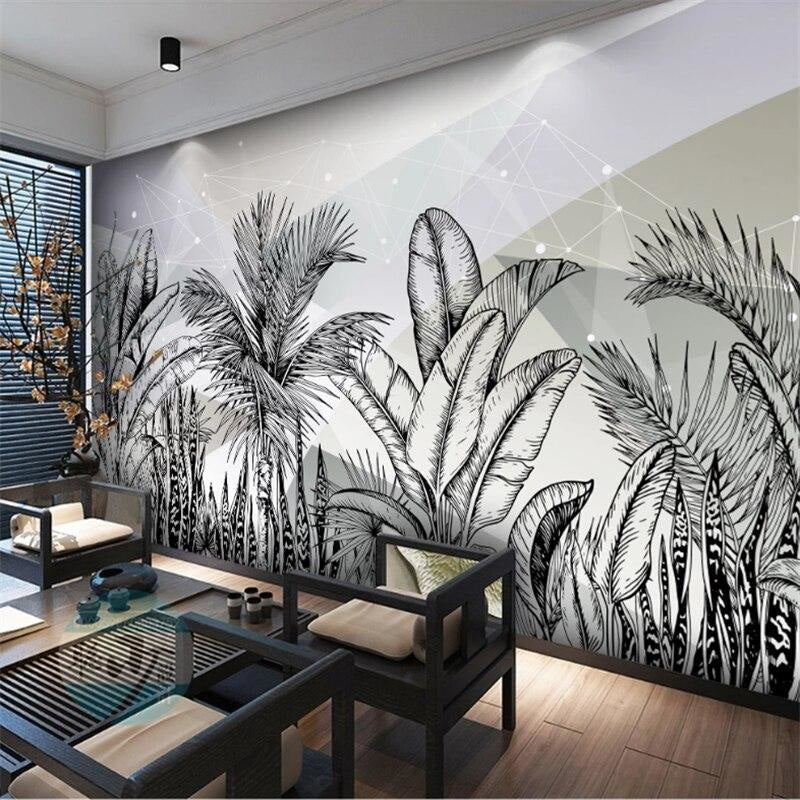 Black and white tropical leaf wallpaper creating a modern statement wall in a minimalist living room