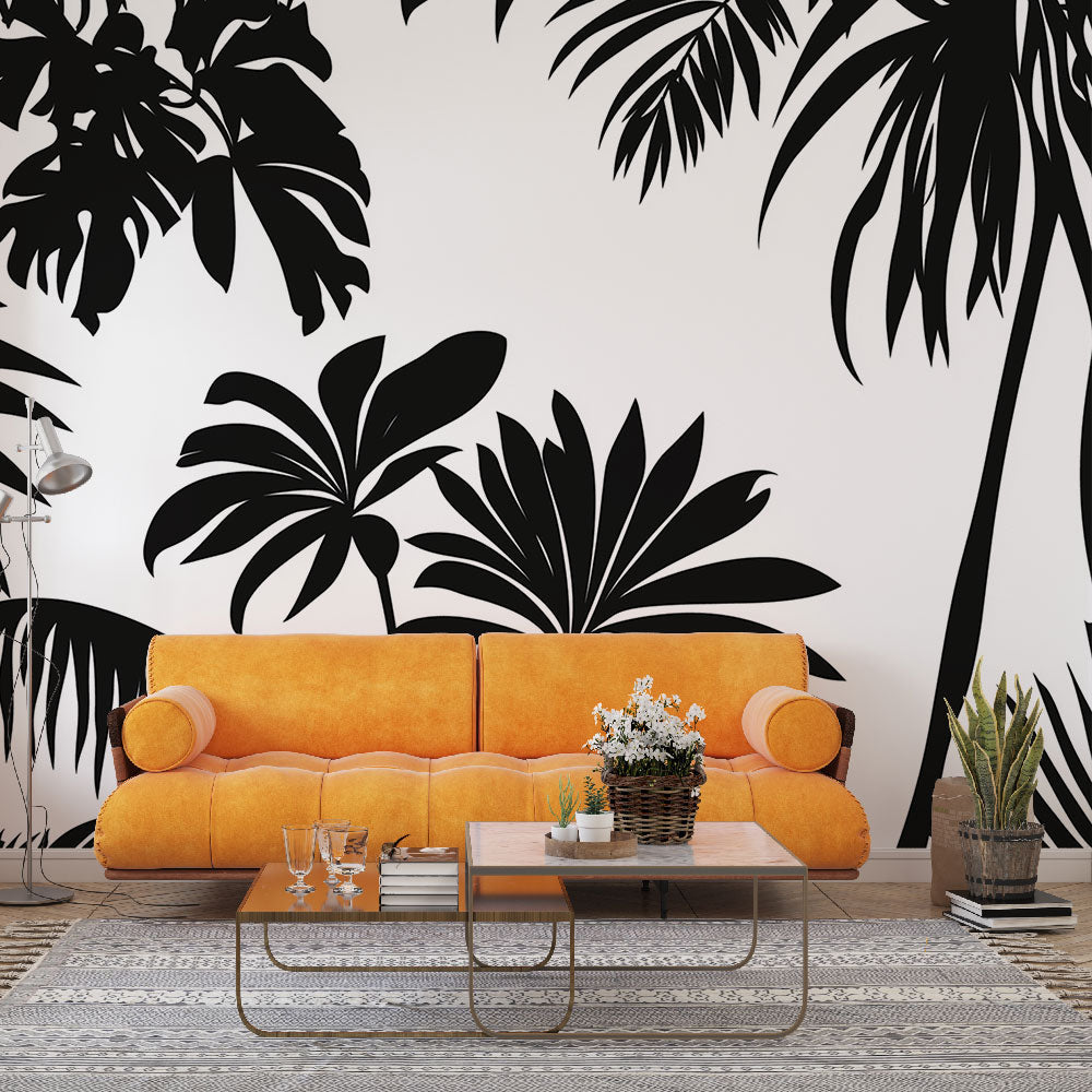 Tropical palm leaves wallpaper creating a stunning monochrome statement wall in a modern living room with minimalist furniture