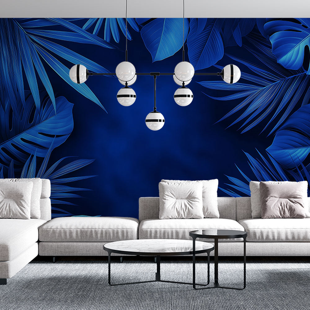 Modern blue Monstera leaf wallpaper creating a stunning accent wall in a minimalist living room with natural light