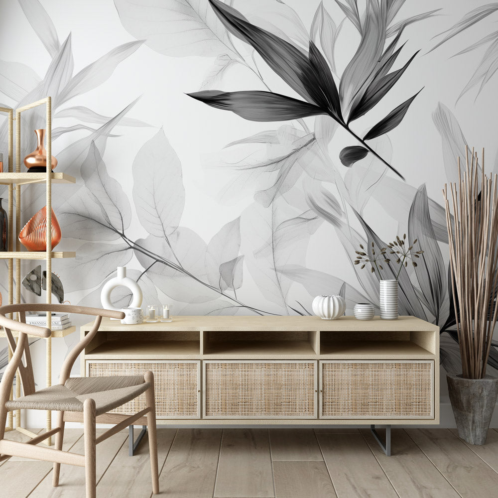 Black and white bamboo leaf wallpaper in modern living room with gray sofa and natural light