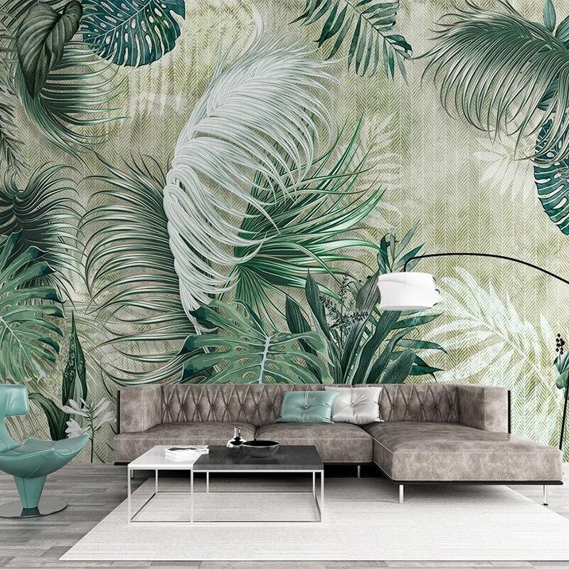 Tropical leaf wallpaper in modern living room with green monstera and palm leaves creating fresh atmosphere