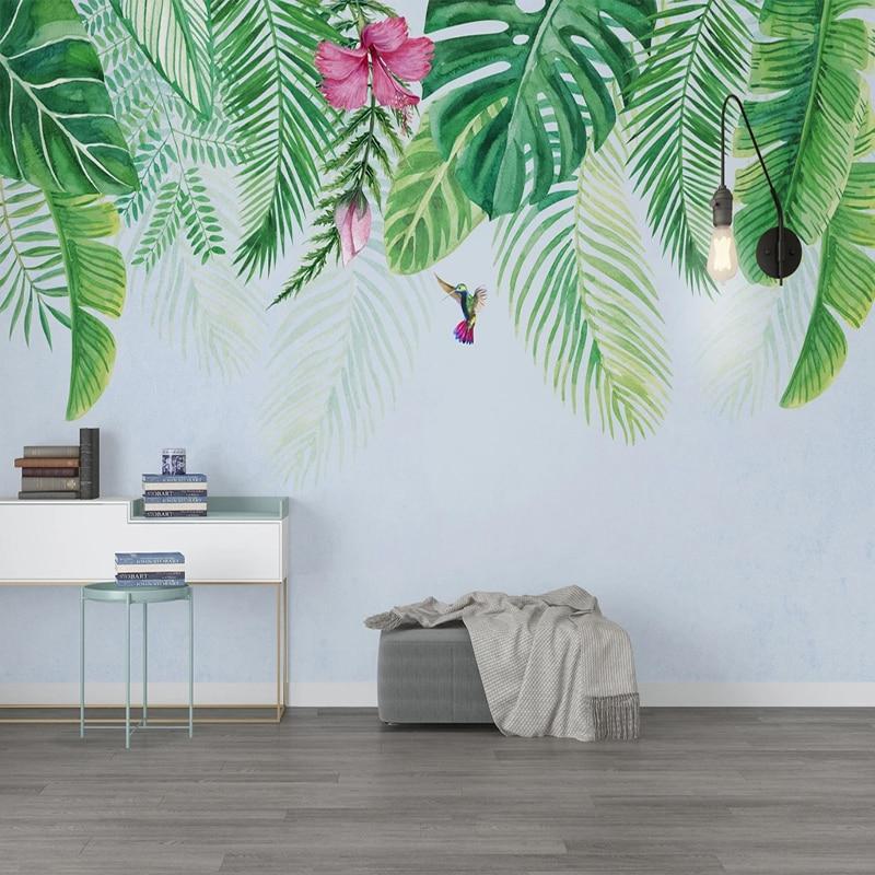 Tropical leaf wallpaper with monstera and hummingbird creating a serene atmosphere in a modern living room