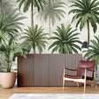 Tropical palm tree wallpaper creating a bright atmosphere in a modern living room with white sofa and natural decor