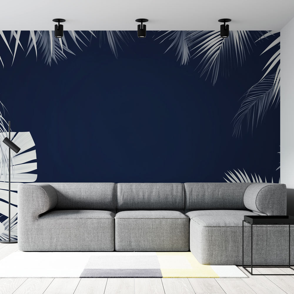 Tropical palm leaf wallpaper creating a sophisticated atmosphere in a modern living room with white and navy contrast