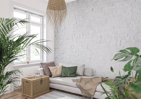 White brick wallpaper in modern minimalist living room with gray sofa and metal accents